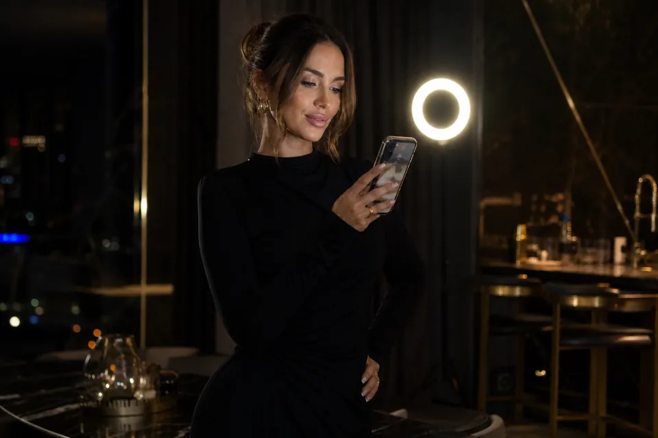 Creator filming content for her subscribers with a phone and a ring light